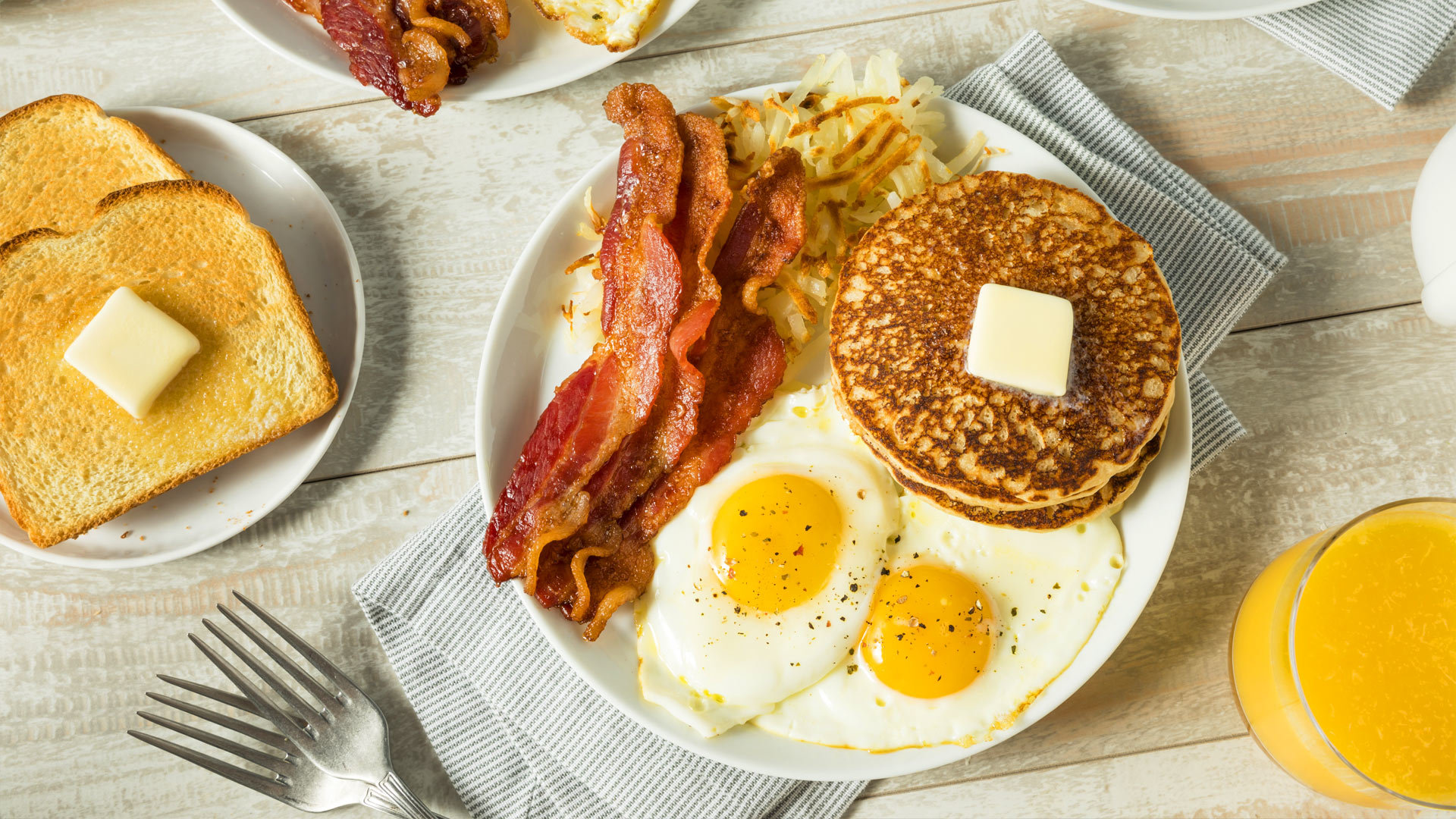 Breakfast plate with pancakes, bacon and eggs